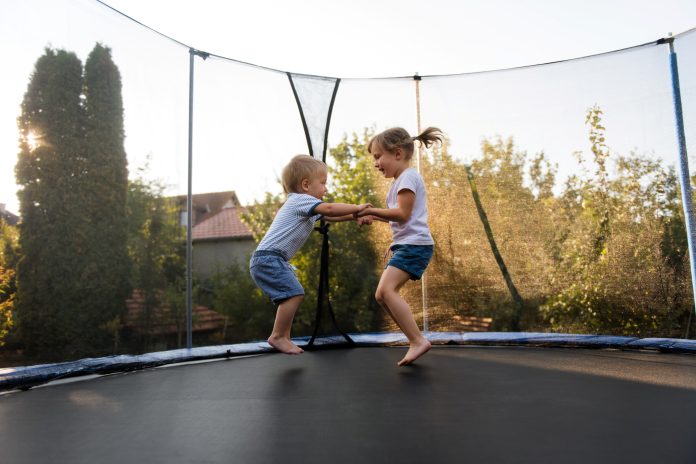 Little kids bouncing off the trampoline taut